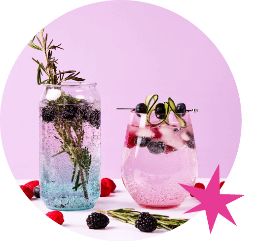 Deux verres remplis d'une boisson pétillante rose clair avec des glaçons, des bleuets, des framboises, des mûres et du romarin. Les verres sont posés sur une table avec des bleuets, des framboises, des mûres et du romarin éparpillés autour. Le fond est mauve avec une étoile bleue dans le coin supérieur droit.